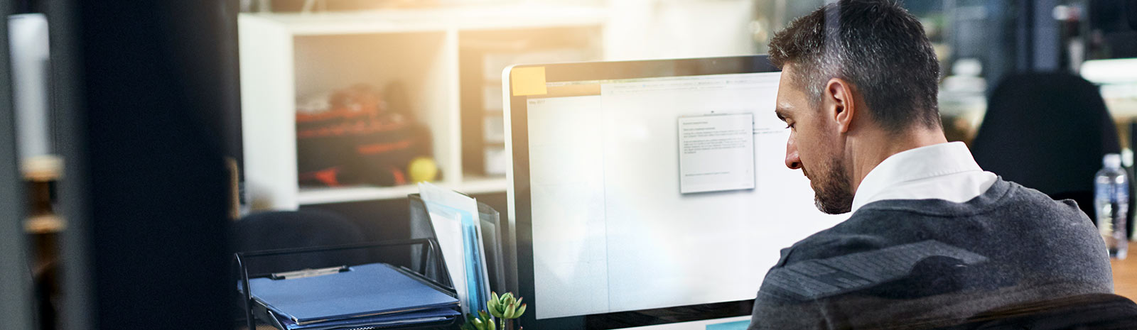 man sitting at a desk in front of a computer