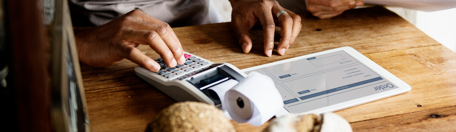 person using tablet and calculator