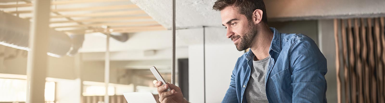 Business man using phone in lobby