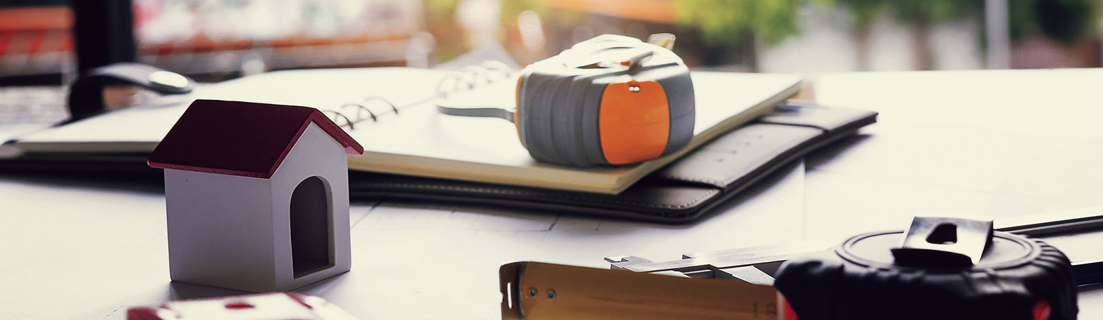 table with a model home and tape measure